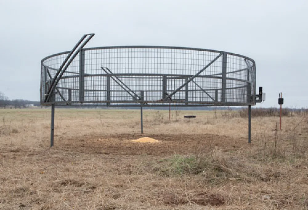 A BoarBuster suspended trap raised over a pasture
